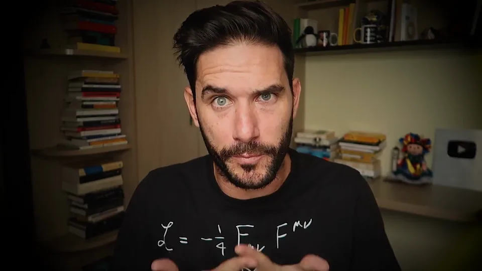 Javier Santaolalla habla a cámara en su estudio, con una camiseta con el lagrangiano del campo electromagnético