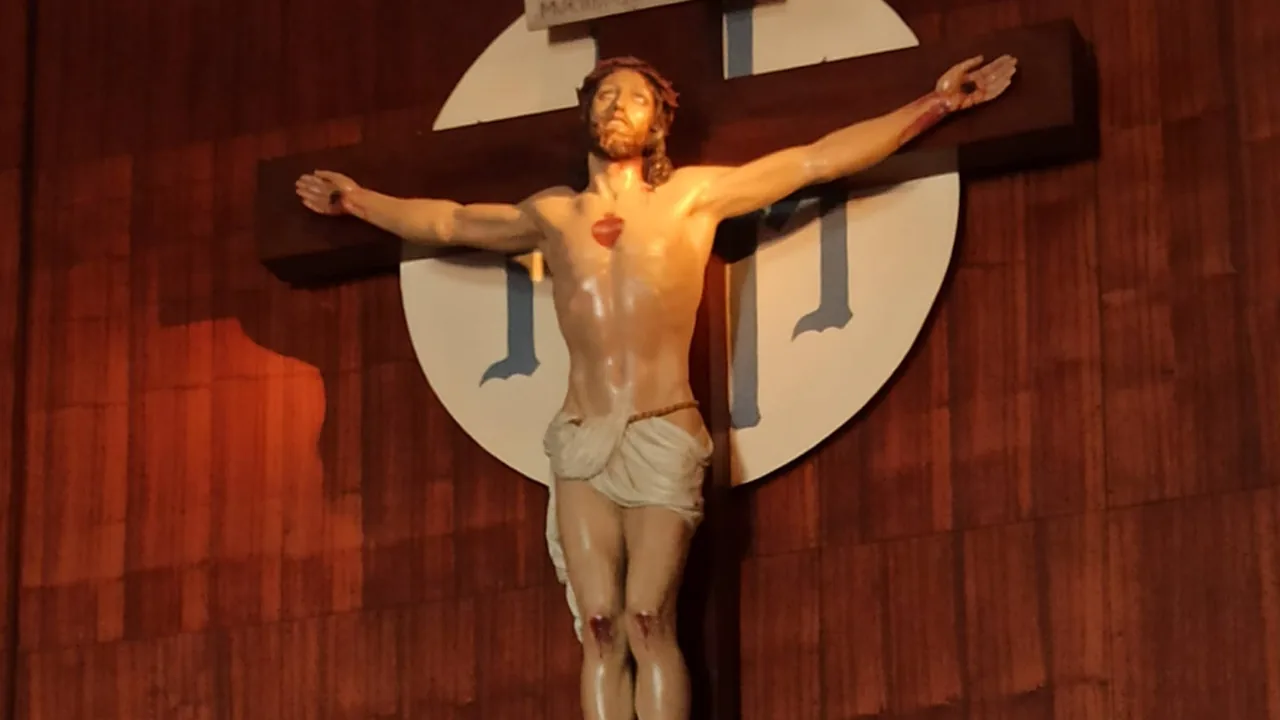 Talla del Cristo crucificado de la capilla del Amor Misericordioso de Collevalenza, de frente, con la cabeza alzada y el corazón pintado en el pecho