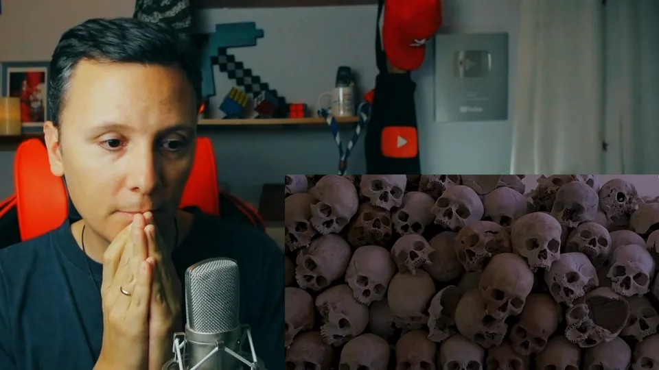 Daniel Pajuelo, con las manos juntas ante la boca, junto a un fragmento del vídeo de Dama G que muestra un montón de calaveras