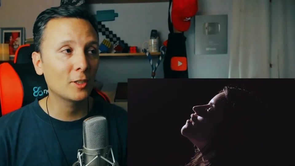 Daniel Pajuelo habla ante el micrófono junto a una silueta que mira hacia arriba en el vídeo de Dama G