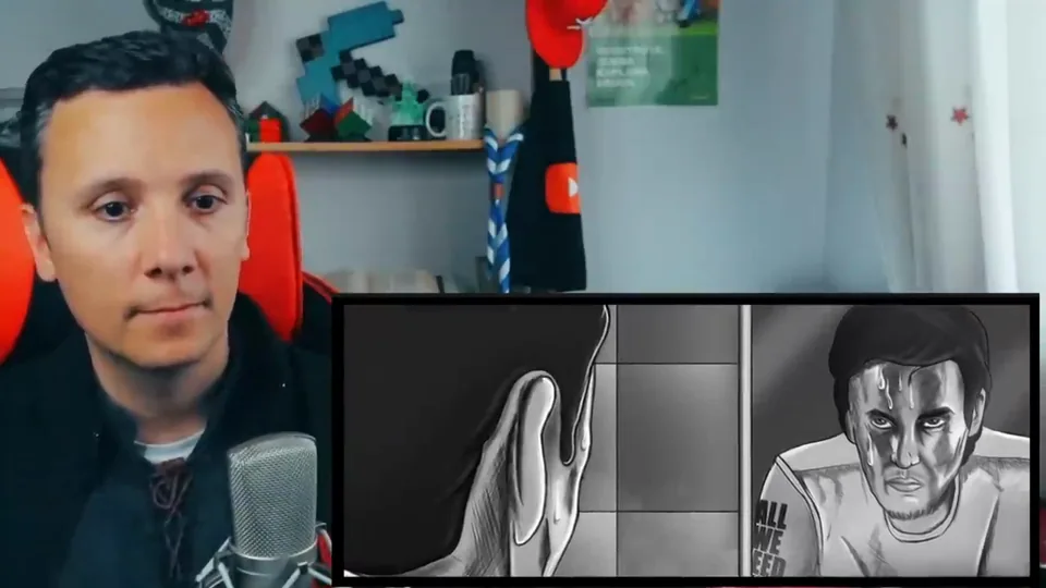 Daniel Pajuelo en su estudio junto a un recuadro del vídeo animado de «Es épico»: un hombre con la cara marcada mira al frente en blanco y negro.
