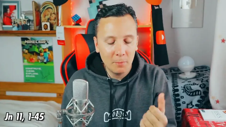 Daniel Pajuelo levanta una mano mientras aparece en pantalla una referencia al Evangelio de Juan.