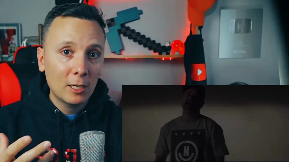 Daniel Pajuelo junto a una imagen de Nach en la penumbra del videoclip Quiero contarte.