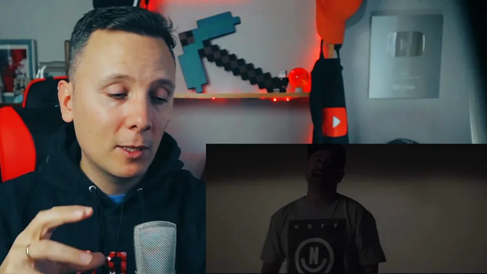 Daniel Pajuelo junto a una imagen de Nach en la penumbra del videoclip Quiero contarte.