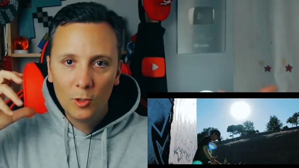 Daniel Pajuelo gesticula junto a una imagen del videoclip Represento junto a un muro pintado.