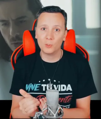 Daniel Pajuelo gesticula durante el comentario de Padre Nuestro, con parte del videoclip detrás.