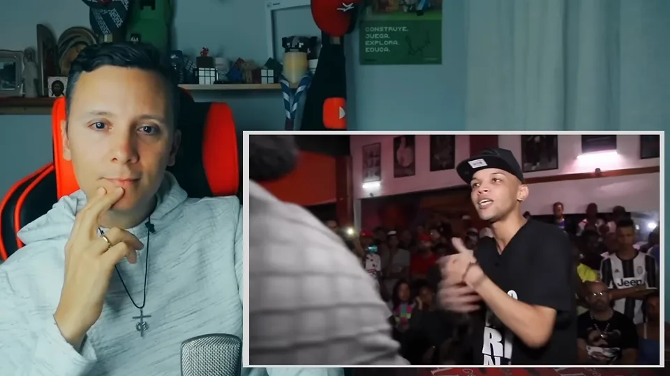 Daniel Pajuelo escucha con la mano junto al rostro mientras comenta la batalla de rap.
