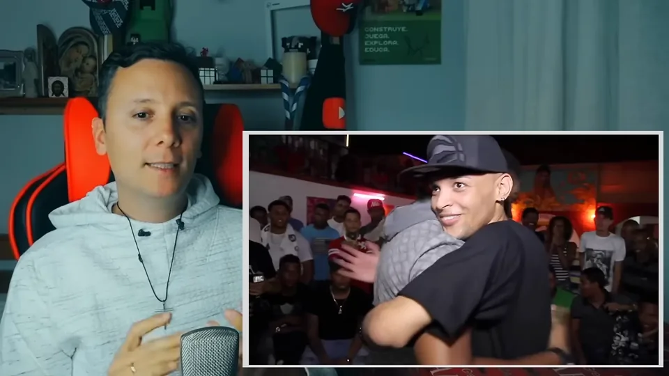 Daniel Pajuelo gesticula junto a un recuadro de la batalla de rap en un local con público.