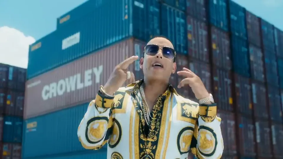 Daddy Yankee, con gafas oscuras, en una escena del videoclip entre contenedores.