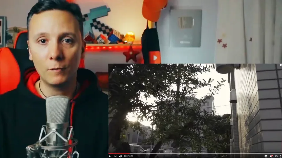 Daniel Pajuelo junto al micrófono y un recuadro con árboles y una fachada del videoclip Luz.