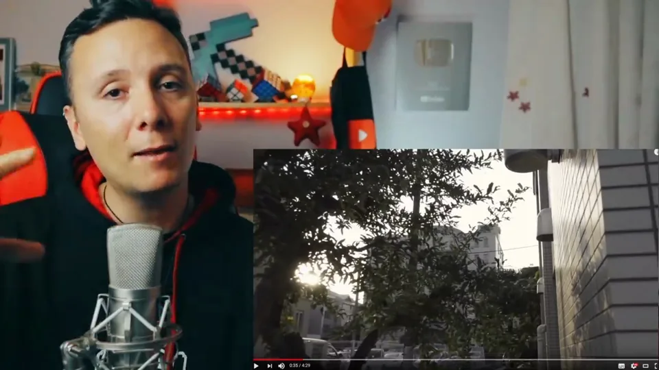 Daniel Pajuelo junto al micrófono y un recuadro con árboles y una fachada del videoclip Luz.